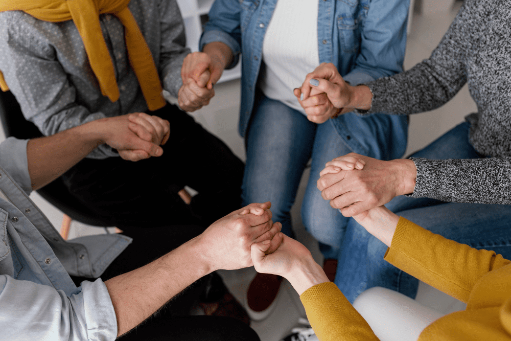 A group of individuals holding hands in support during recovery sessions at a Meth Detox in Nashville, fostering connection and healing together.